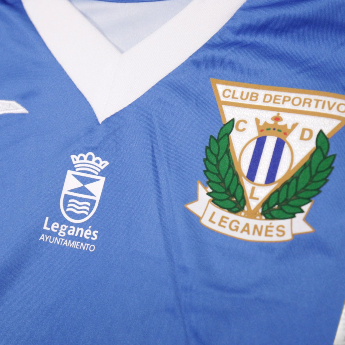 Close-up of the CD Leganés crest and Leganés Ayuntamiento badge on the chest