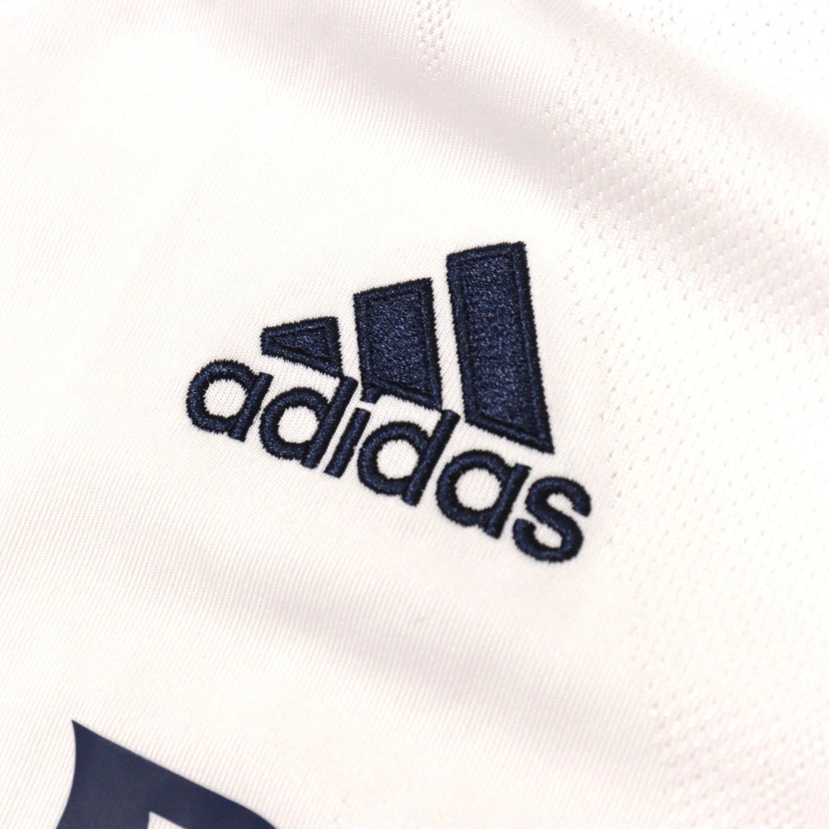 Close-up of adidas logo on chest