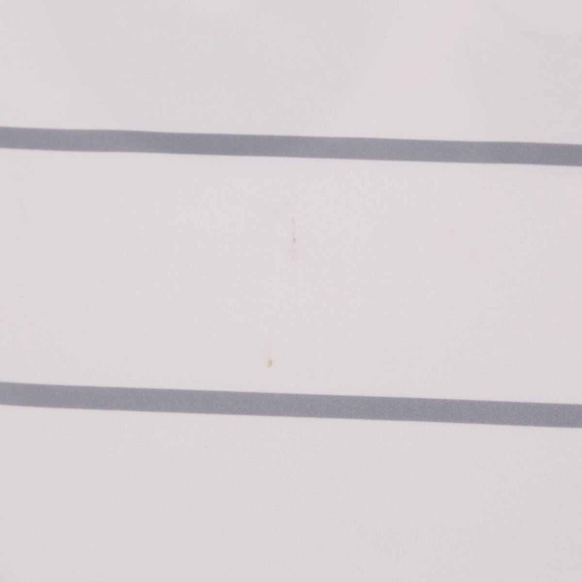 Close-up of grey stripe detailing with a faint mark on the shirt body