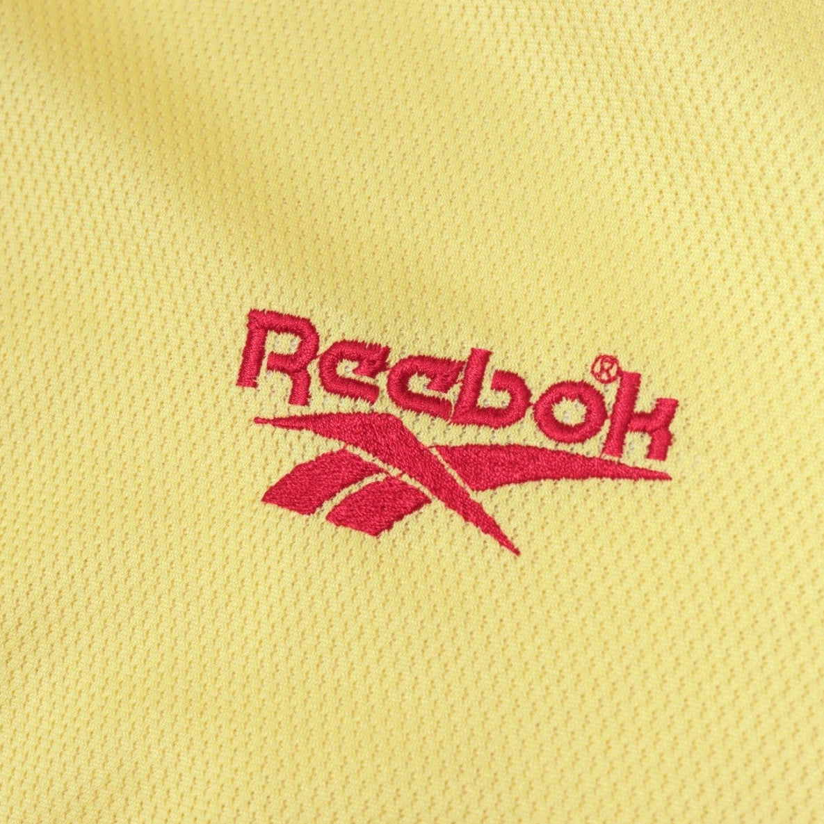 Close-up of the embroidered Reebok logo on the shirt fabric
