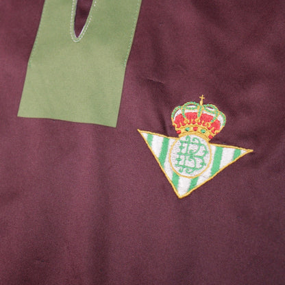Close-up of the Real Betis crest and green v-neck placket