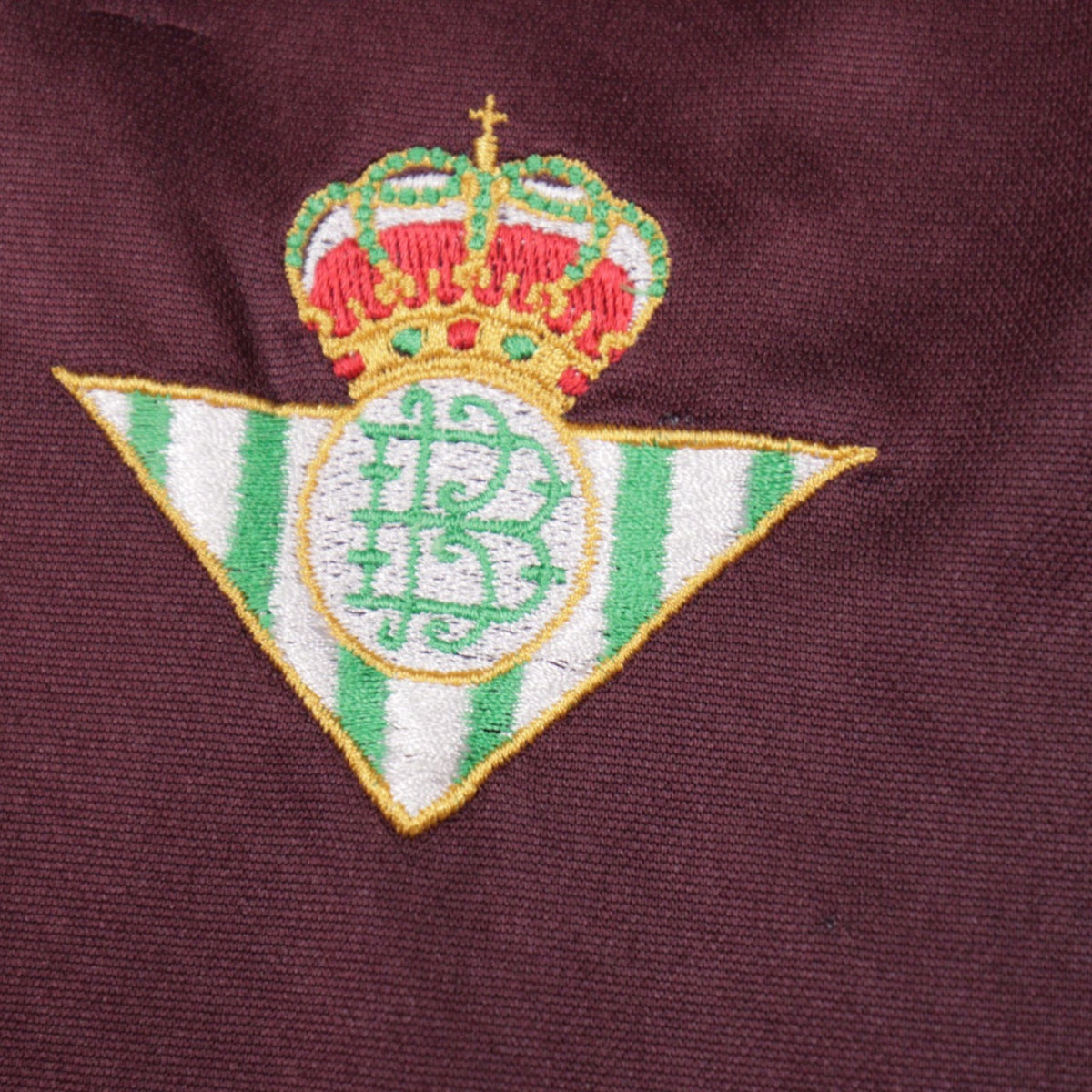 Close-up of the Real Betis crest embroidery showing a small mark in the fabric