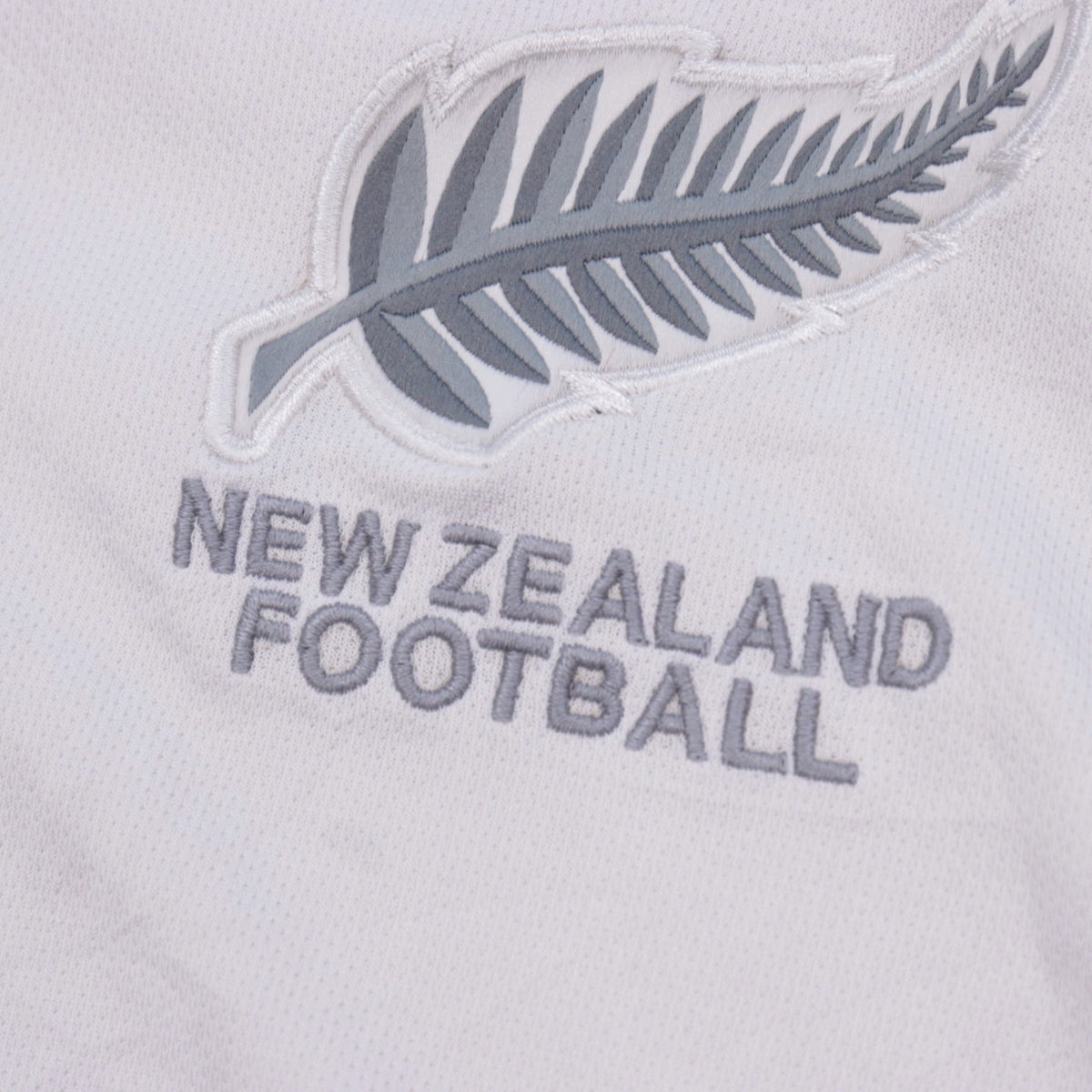 Close-up detail of the silver fern crest embroidery