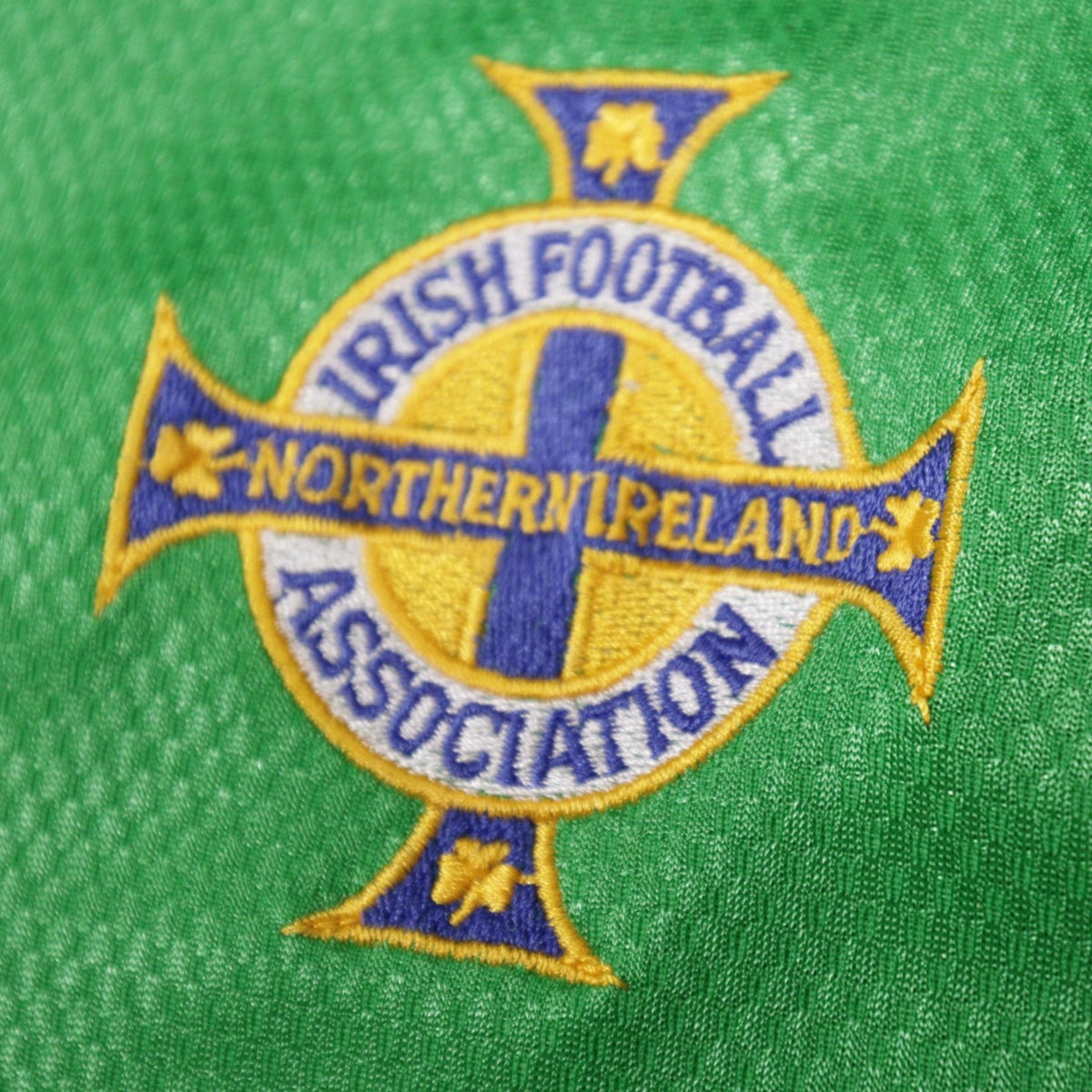 Close-up of the embroidered Irish Football Association crest on the Northern Ireland home shirt