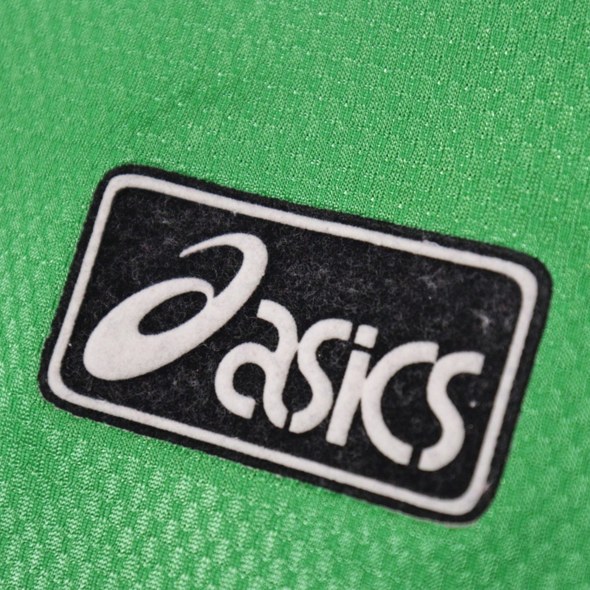 Close-up of the Asics logo on the chest of the Northern Ireland home shirt