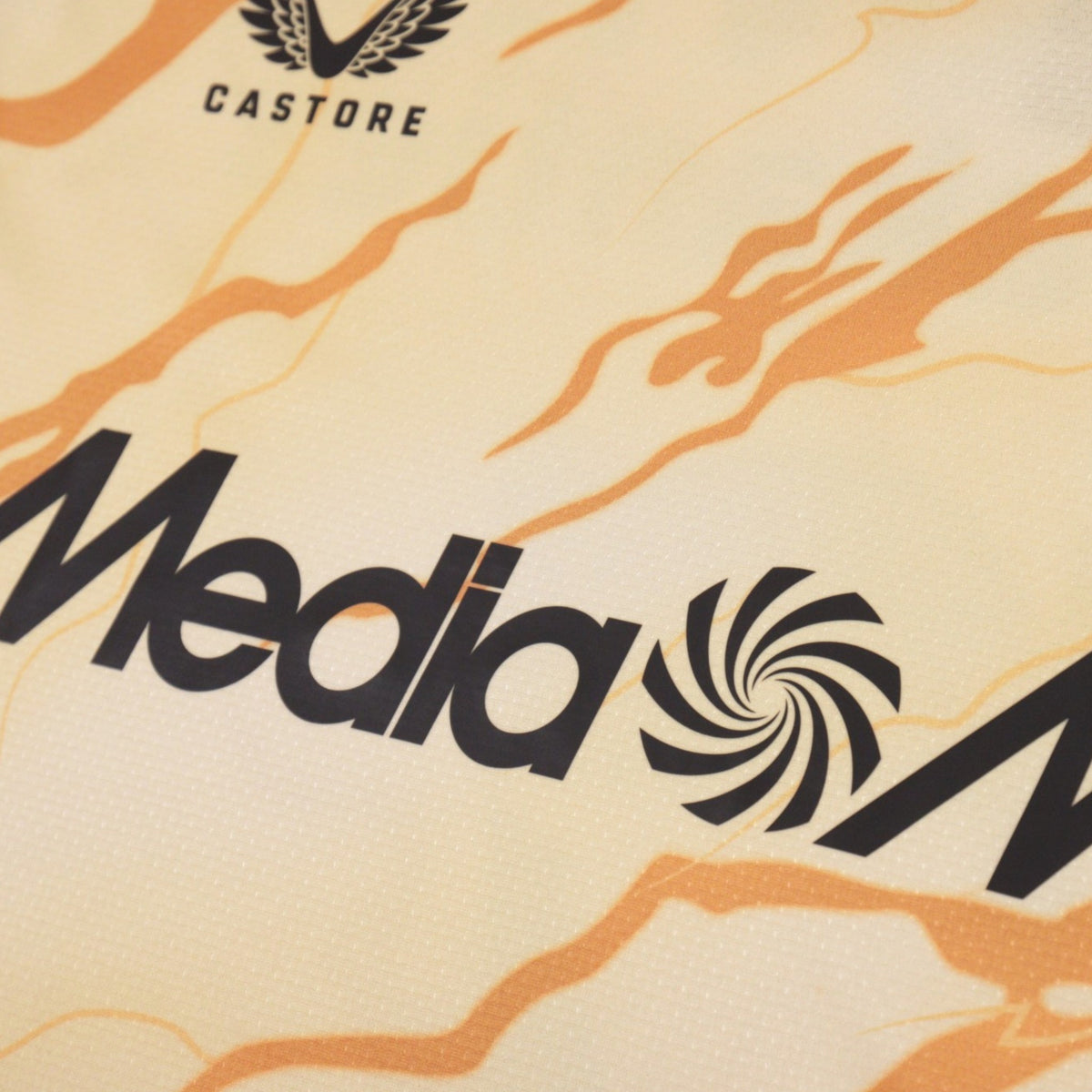 Close-up of Castore logo and MediaMarkt sponsor on front of shirt