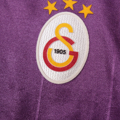 Close-up of the Galatasaray crest showing three stars and 1905 founding date
