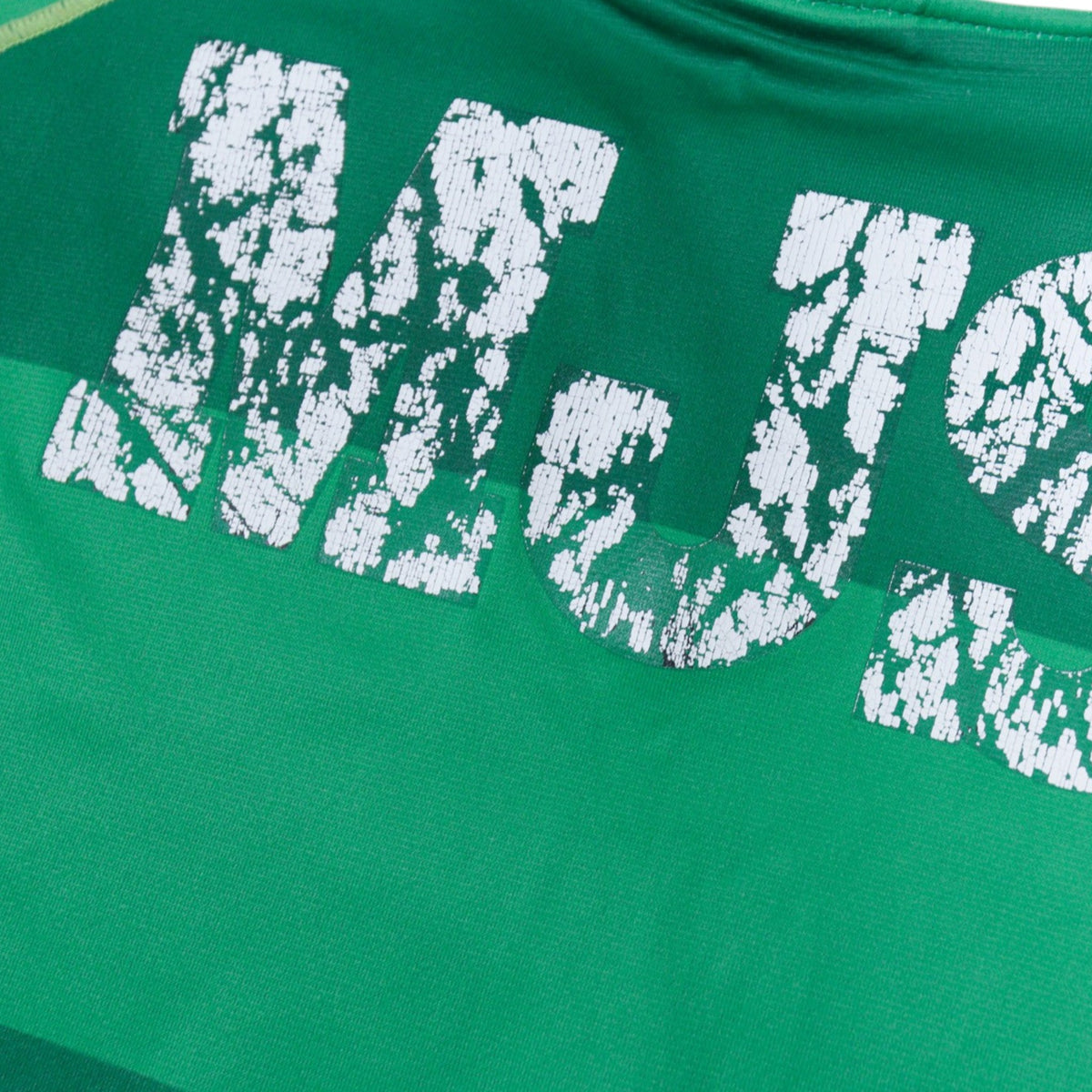 Close-up of the 'MJS' print on the back of the shirt showing cracking