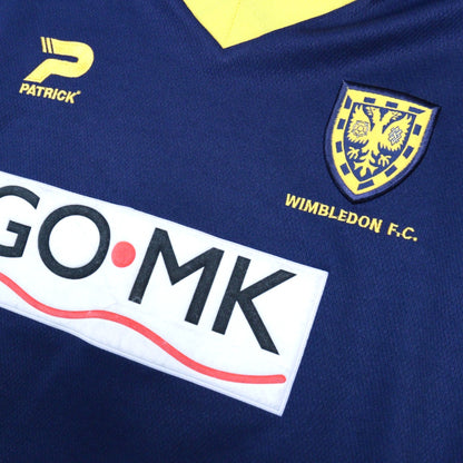 Close-up of the Patrick logo, Wimbledon FC crest and GO·MK sponsor on the chest