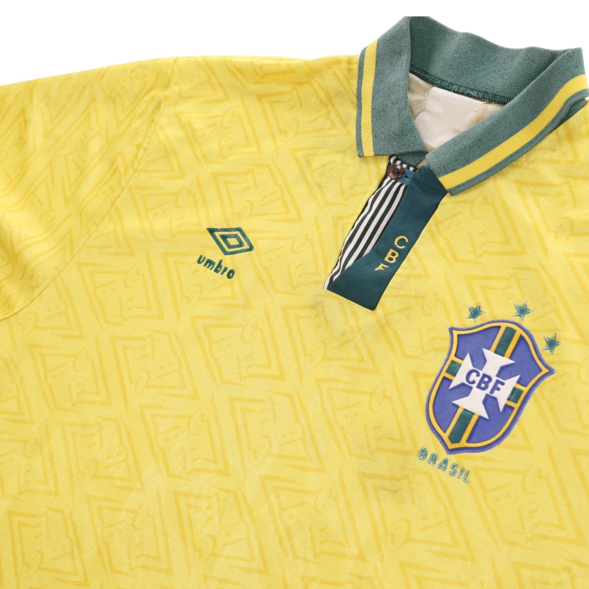 Close-up of CBF crest, Umbro logo and striped collar on Brazil home shirt