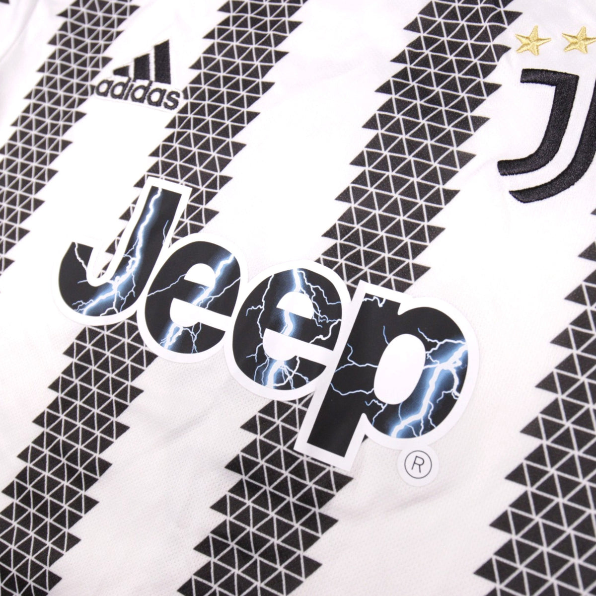 Close-up of adidas logo, Jeep sponsor and Juventus crest on the shirt front