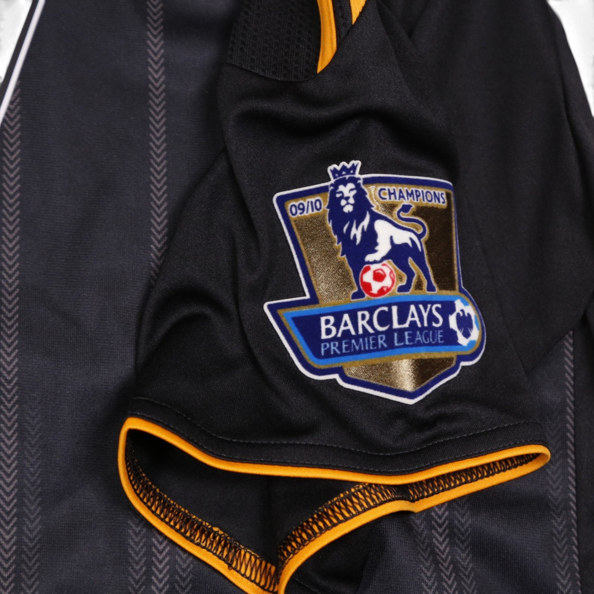 Close-up of Barclays Premier League 09/10 champions badge on sleeve with orange cuff trim