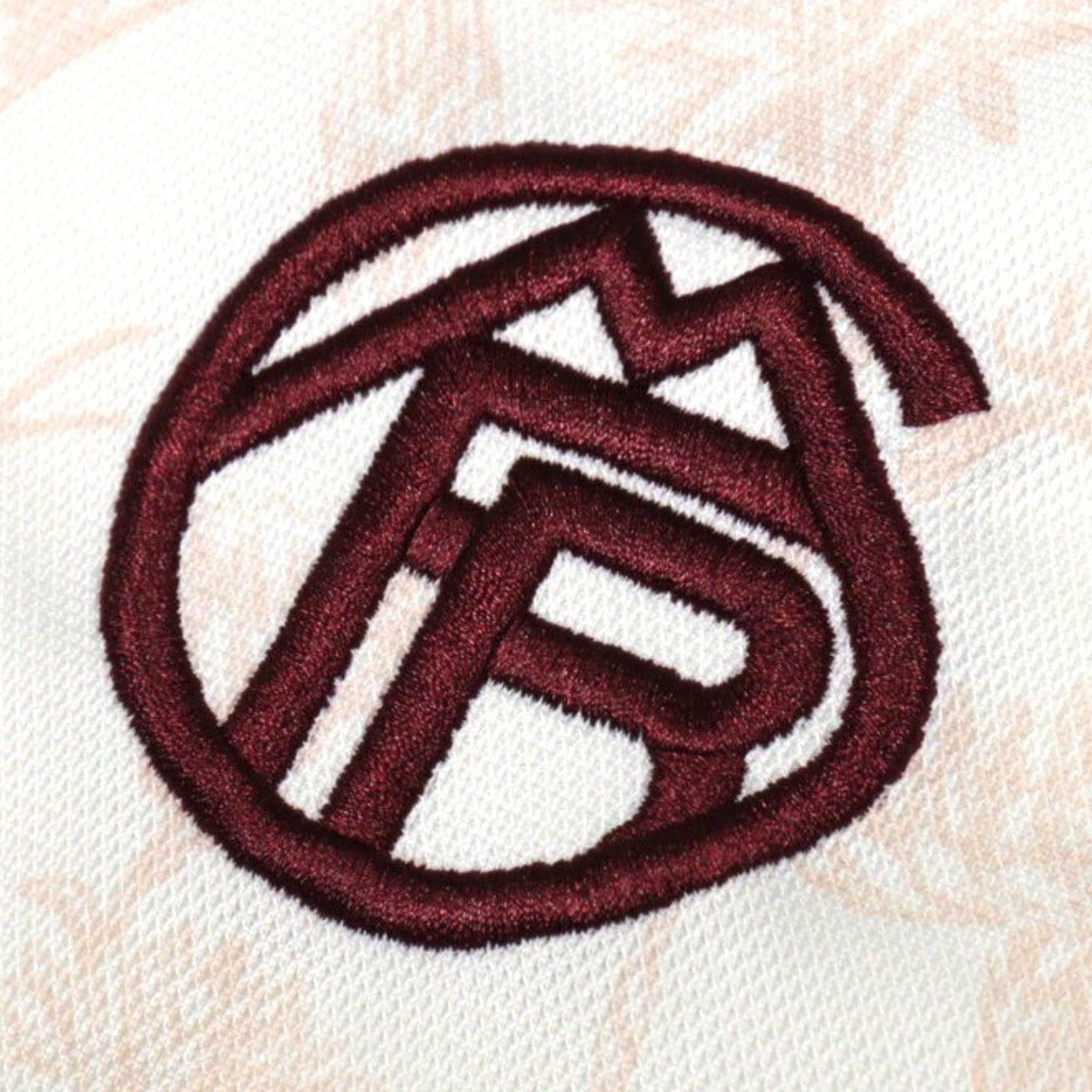 Close-up of embroidered Bayern Munich crest in maroon