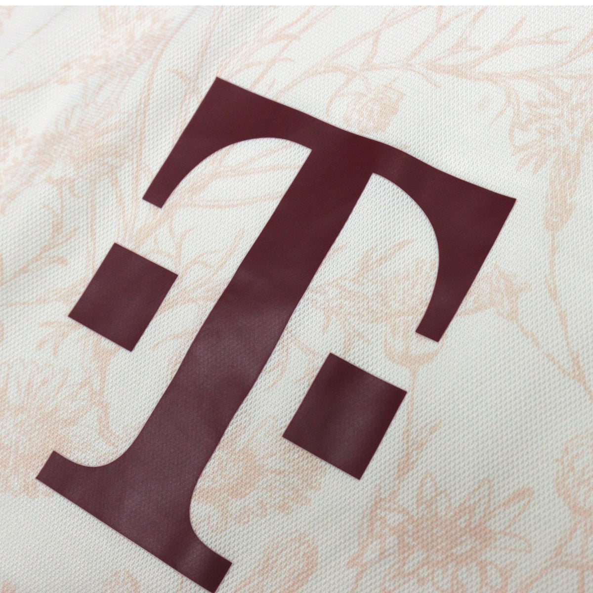 Close-up of Telekom sponsor logo in maroon on the chest