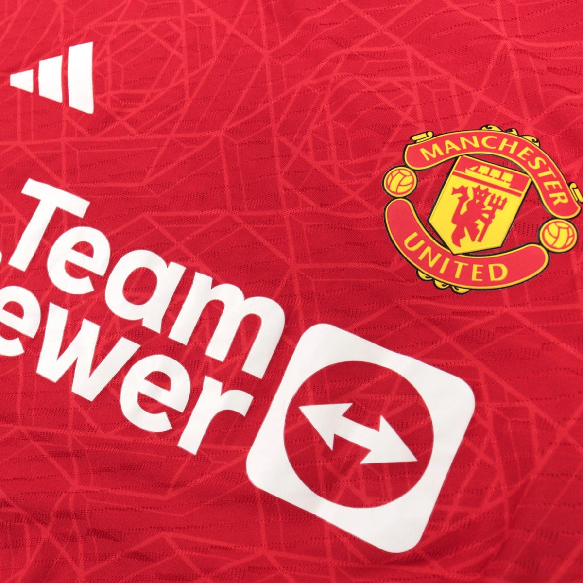Close-up of the adidas logo, TeamViewer sponsor and Manchester United crest on the chest