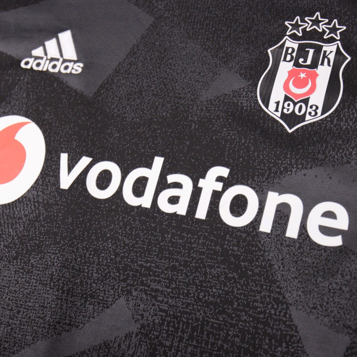 Close-up of the adidas logo, Besiktas crest and Vodafone sponsor on the front of the shirt
