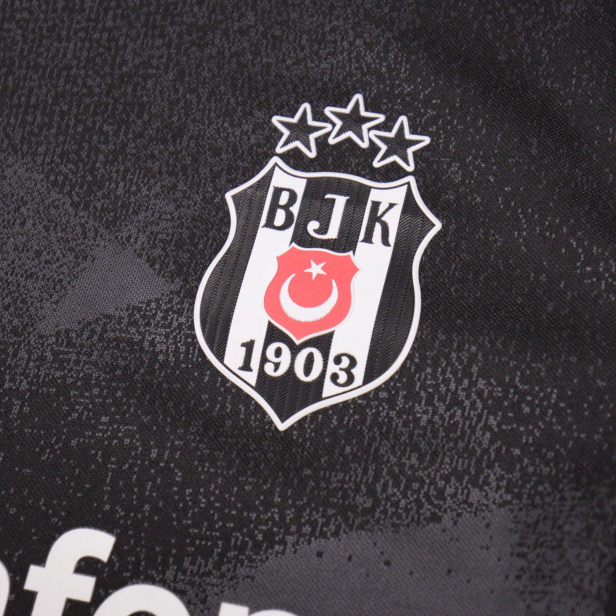 Close-up of the Besiktas three-star crest on the shirt