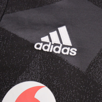 Close-up of the adidas logo and camouflage fabric pattern