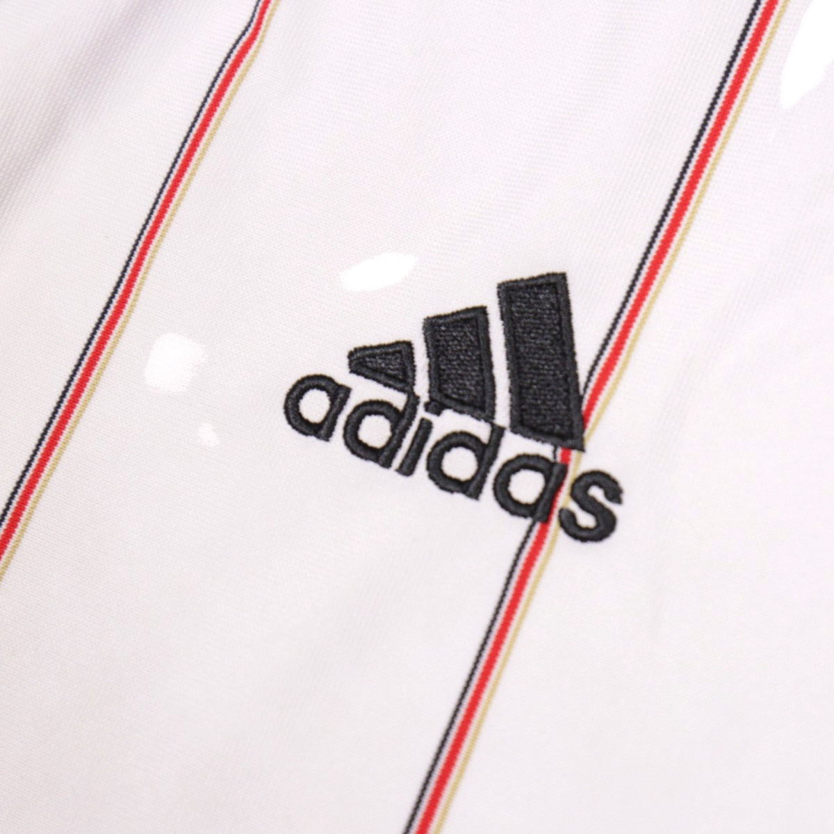 Close-up of the adidas logo and pinstripe detailing on the shirt
