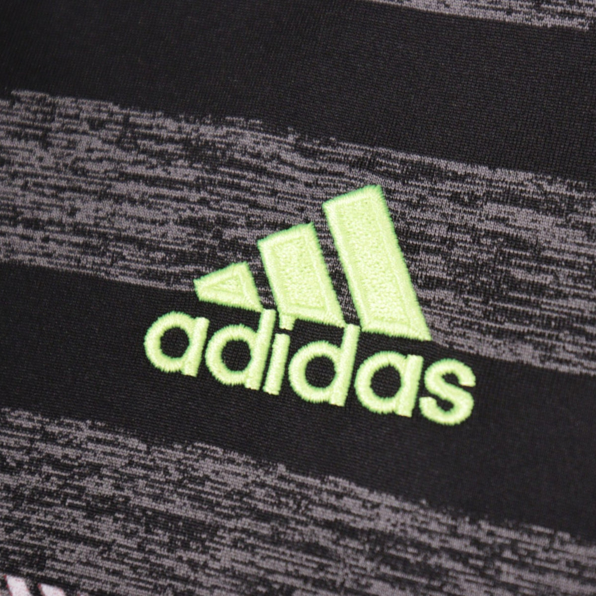 Close-up of the adidas logo on the shirt fabric