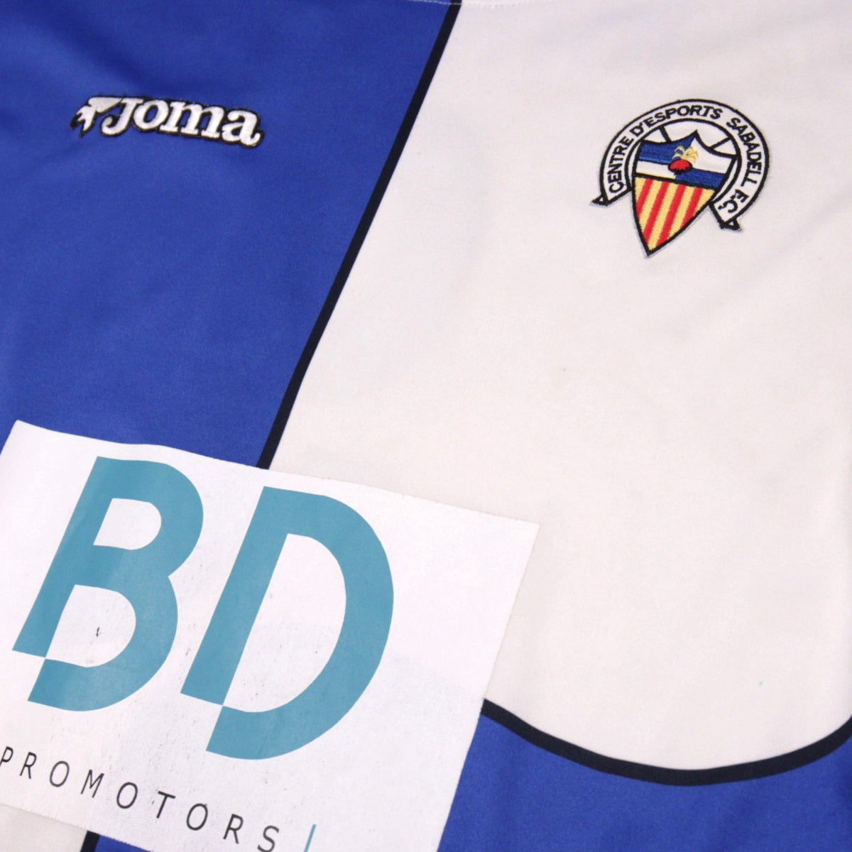 Close-up of Joma logo and Sabadell crest on the front of the shirt