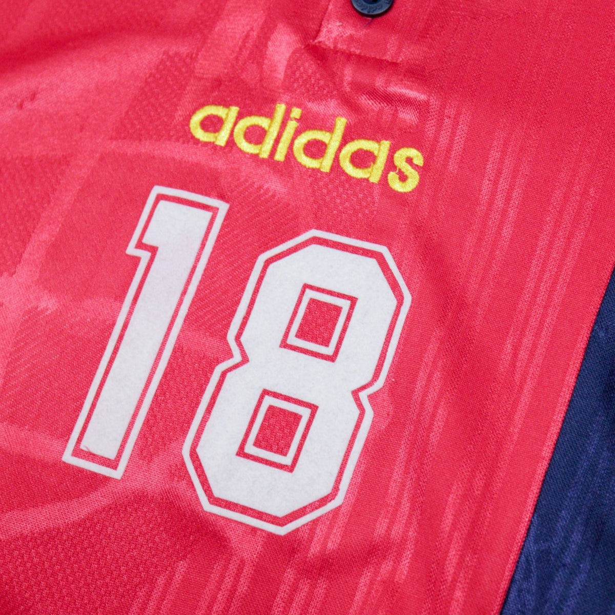 Close-up of adidas logo and number 18 on the chest