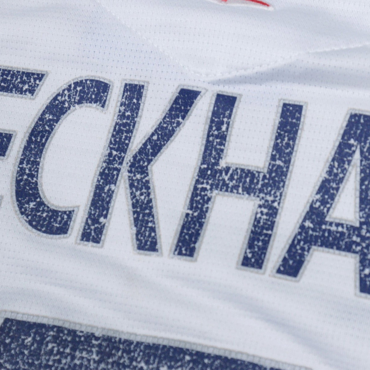 Close-up of the cracked BECKHAM print on the back of the shirt