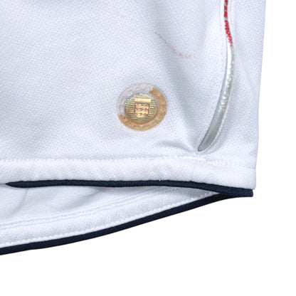 Close-up of the hem showing a gold hologram tag and a faint mark