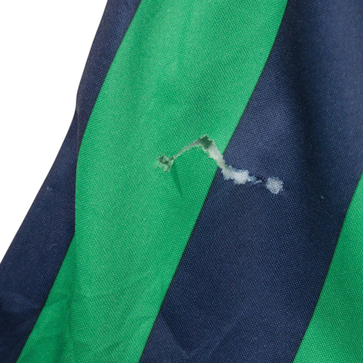Close-up of small hole and snagged threads on the lower back of the shirt