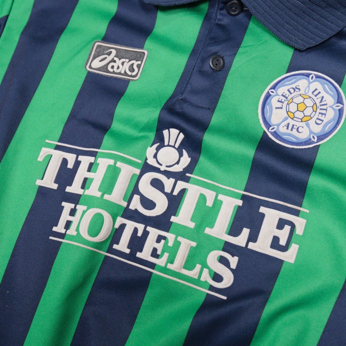 Close-up of Asics logo, Leeds United crest and Thistle Hotels sponsor on the chest