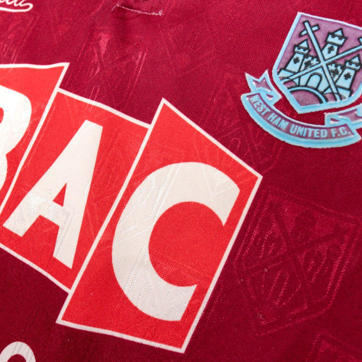 Close-up of BAC Windows sponsor and West Ham United crest on the shirt