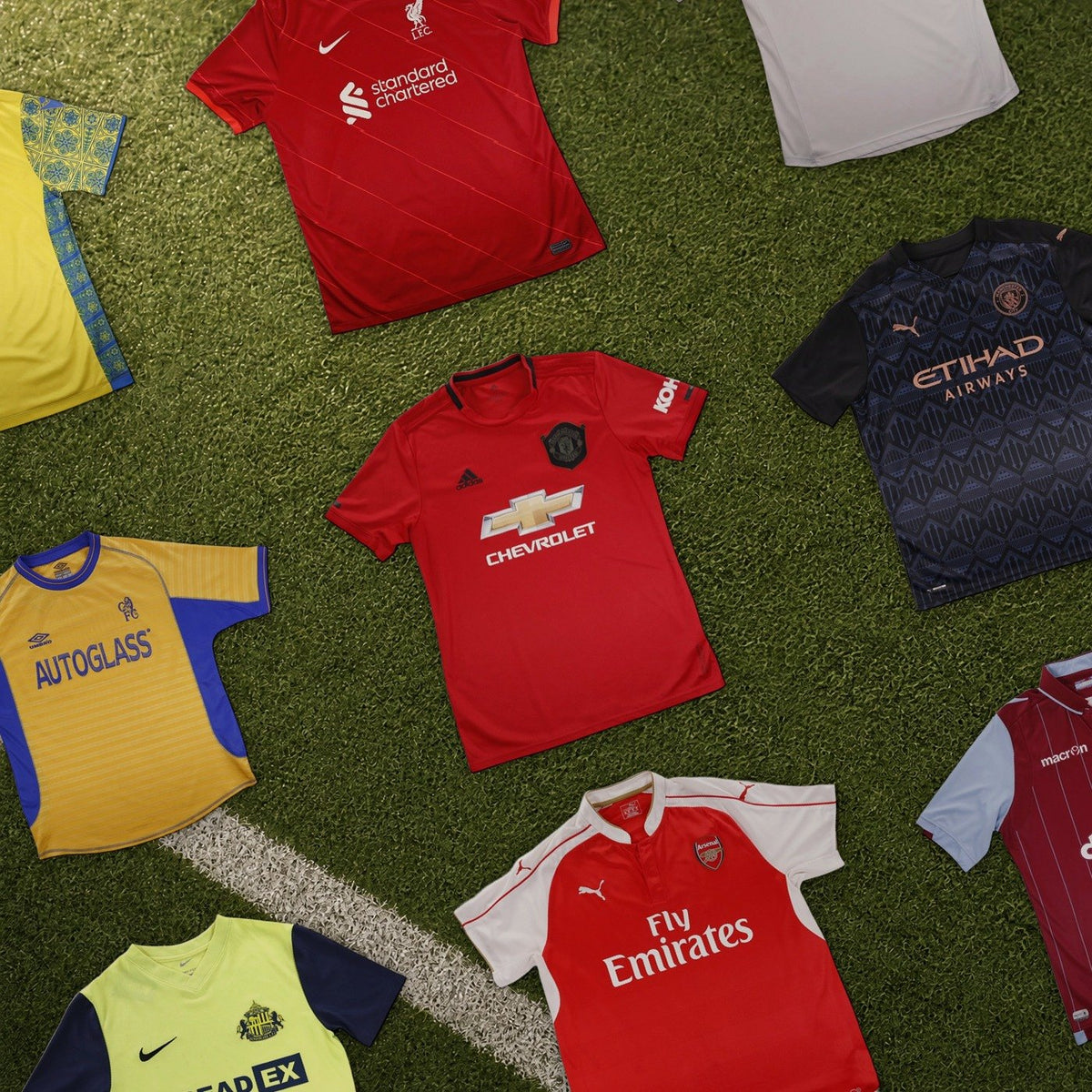 Premier League shirts from the shop laid out on a football pitch